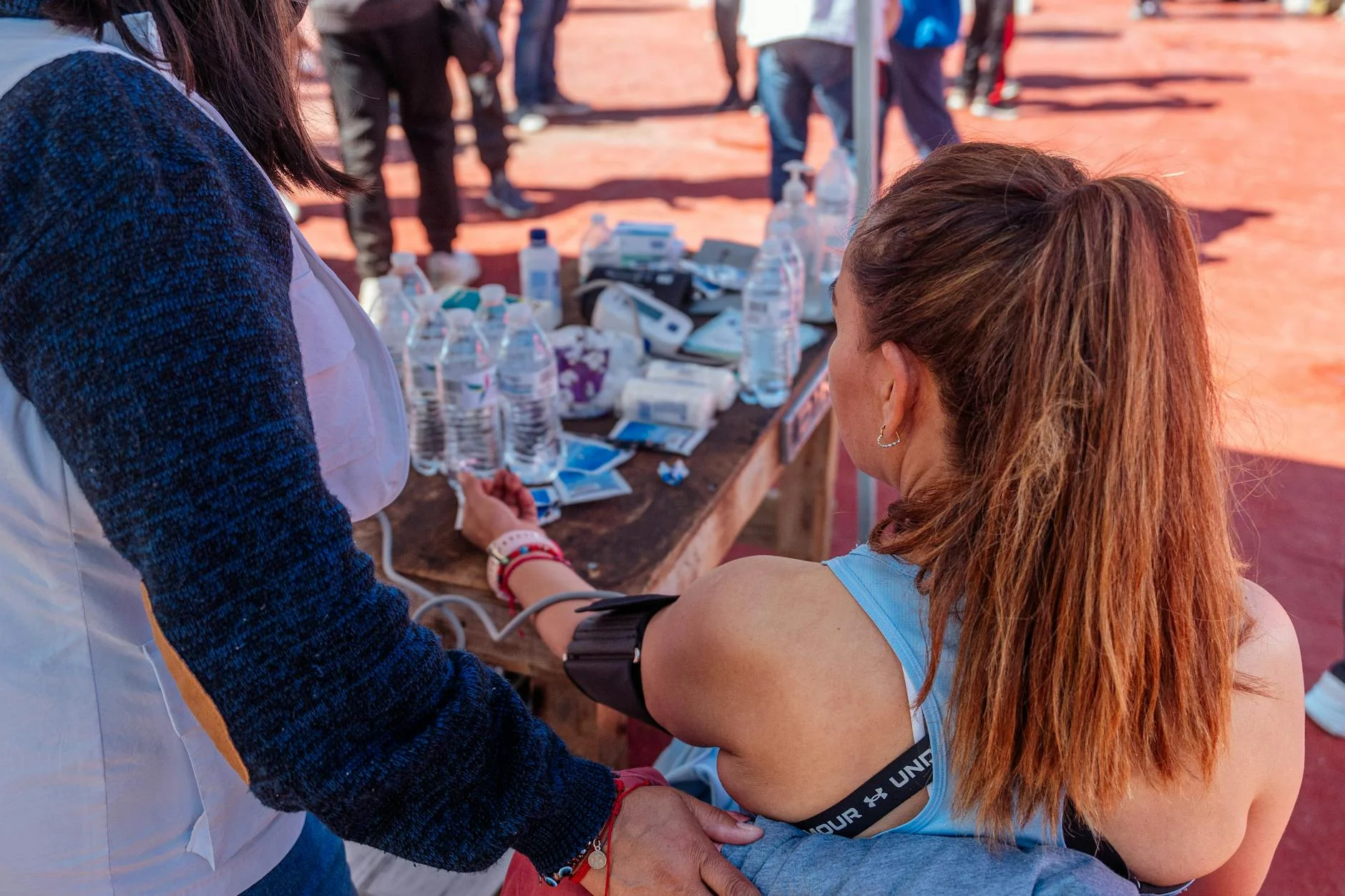 Woman in sportswear undergoing a health check outdoors during a sports event.